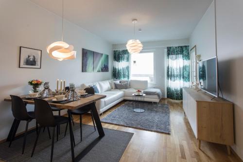 uma sala de estar com uma mesa e um sofá em Tuomas´ luxurious suites, Nouka em Rovaniemi