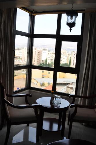 a table and two chairs in front of a window at Al Zaitouna Hotel in Aqaba