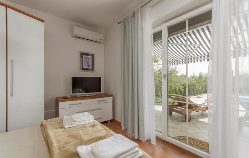 Villa Rosa في Nova Vas: غرفة نوم بسرير وتلفزيون وشرفة