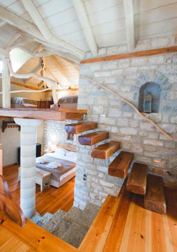 a room with a stone wall with a stone fireplace at Artsistas Houses in Aristi