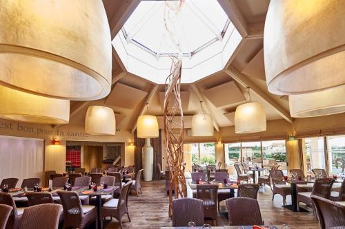 a restaurant with tables and chairs in a room at ibis Styles Cholet in Cholet