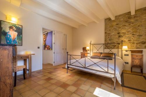 a bedroom with a bed and a stone wall at Can Caranta in Pals