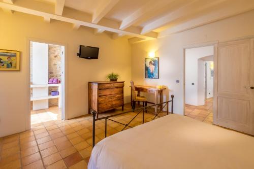 a bedroom with a bed and a tv on the wall at Can Caranta in Pals