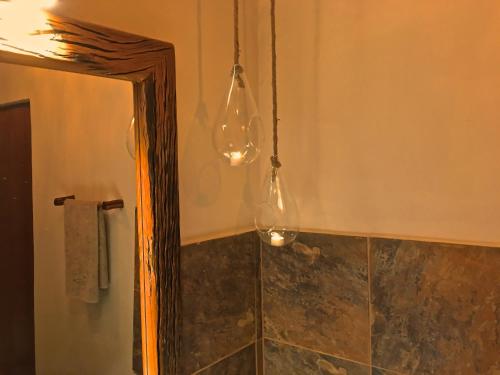 a bathroom with a mirror and lights in it at Lamai Safari Lodge in Balule Game Reserve