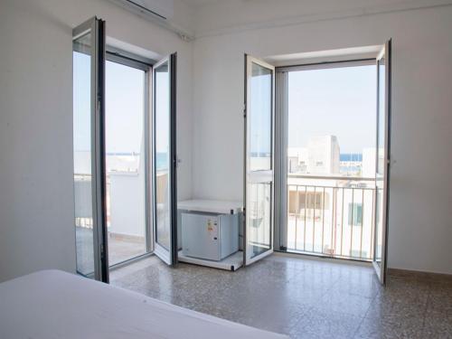 una camera da letto con porte scorrevoli in vetro e balcone di Hotel Morini a San Foca