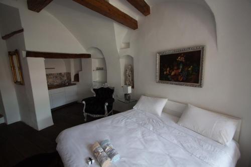 a bedroom with a white bed and a chair at Vestonicka Moruse in Dolní Věstonice