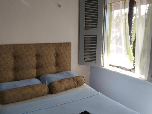 1 cama en un dormitorio con ventana en Blue Day, en Canoa Quebrada