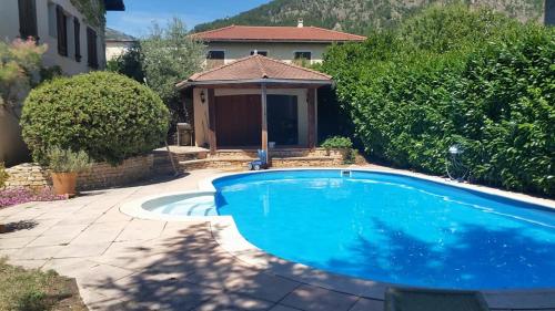 une grande piscine bleue dans une cour dans l'établissement Au Paradis des Grillons, à Espinasses