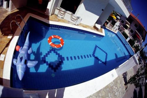 an overhead view of a swimming pool with a life preserver at Hotel Eden in Nei Poroi