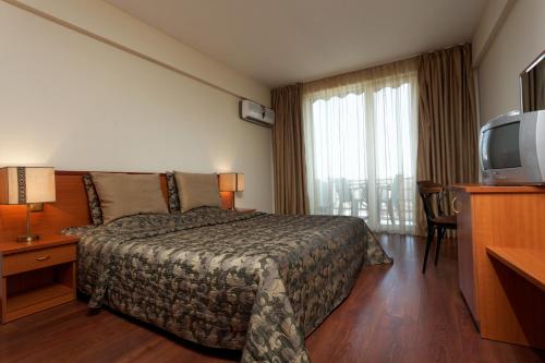 a hotel room with a bed and a television at Hotel Kabakum in Golden Sands