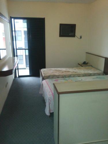 um quarto de hotel com uma cama e uma janela em Flat - Palladium Apart Service em São Vicente