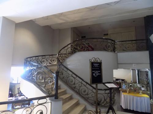 a spiral staircase in a room with a table at Hotel San Marcos Express in Culiacán