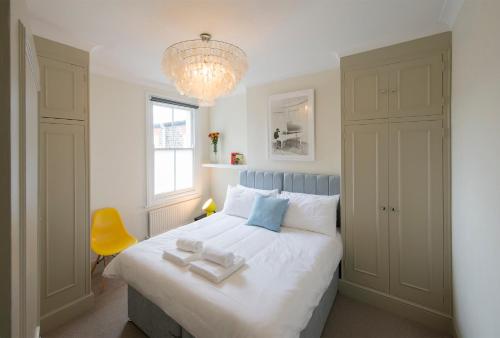 a bedroom with a large white bed with a chandelier at Yellow Submarine London in London