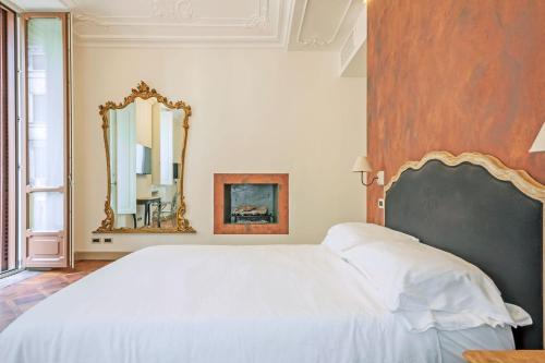 sypialnia z białym łóżkiem i lustrem w obiekcie Europrooms - Torino Centro w Turynie