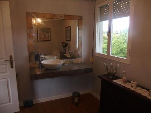 a bathroom with two sinks and a large mirror at Zikoinaren Txokoa ( El Txoko de la cigüeña ) in Orduña