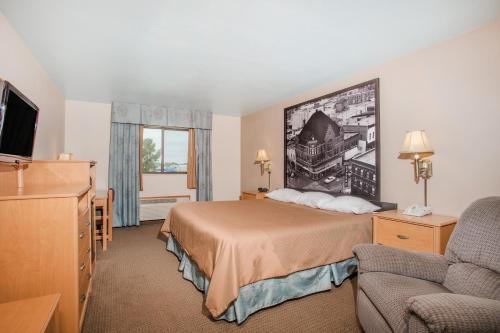 een hotelkamer met een bed en een televisie bij Super 8 by Wyndham Monroe WI in Monroe