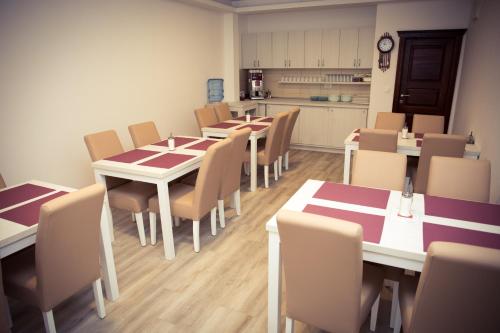 una sala con tavoli e sedie e una cucina di Villa Bojcic a Mostar