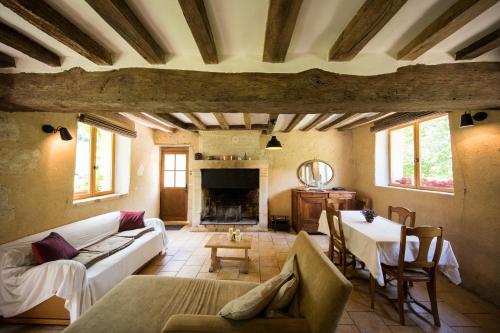 ein Wohnzimmer mit einer weißen Couch und einem Tisch in der Unterkunft Holiday home Le Vaugarnier in Couture-sur-Loir