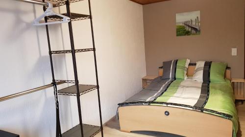 a bedroom with a bed with green and white pillows at "Sous les Barres" in Montfaucon