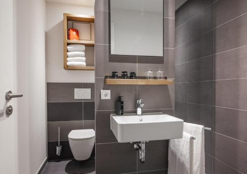 a bathroom with a sink and a toilet at Staycity Aparthotels Dresden City Centre in Dresden
