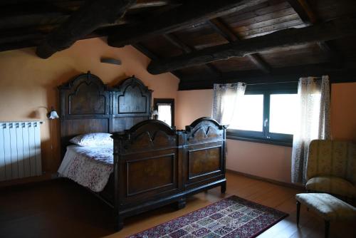 - une chambre avec un grand lit en bois et une fenêtre dans l'établissement Il borgo, à Montabone
