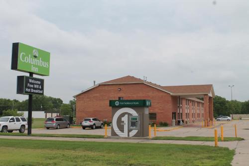 a building with a sign in front of a parking lot at Columbus Inn in Columbus