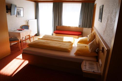 een hotelkamer met 2 bedden en een tafel bij Der Oswalderhof in Obertilliach