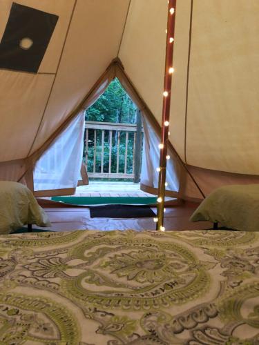 uma tenda com uma cama num quarto com uma janela em Glampin' In Style-Broken Bow em Broken Bow