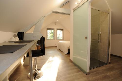 a bathroom with a glass shower and a bedroom at Le Parc Stanislas in Chartres