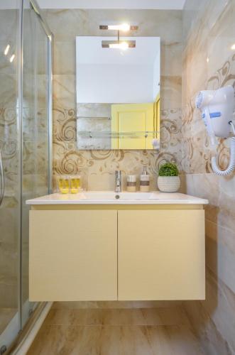 a bathroom with a sink and a mirror at Kapris House in Agios Prokopios