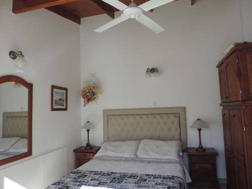 a bedroom with a bed and a ceiling fan at Hosteria Las Piedras in Puerto Madryn