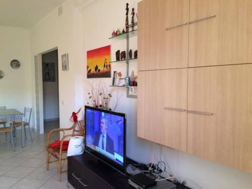 a living room with a flat screen tv on a cabinet at Una finestra sul mare in Cogoleto