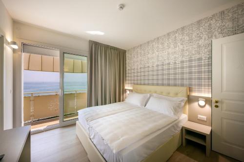 a bedroom with a bed and a large window at Hotel Le Lampare in Caorle