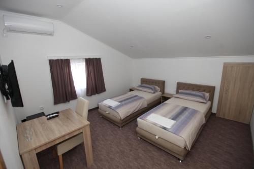 a hotel room with two beds and a table at Ninkovic in Trebinje