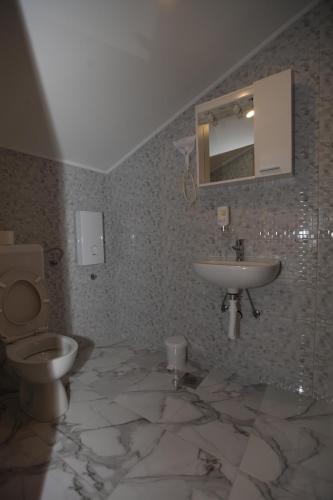 a bathroom with a sink and a toilet and a mirror at Ninkovic in Trebinje