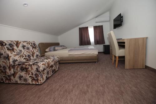 a hotel room with a bed and a couch and a desk at Ninkovic in Trebinje