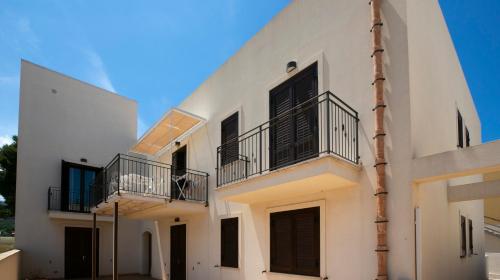 a white building with black balconies on it at Boa Vista San Vito - Area Fitness, Barbecue Area, Tennis Court in San Vito lo Capo