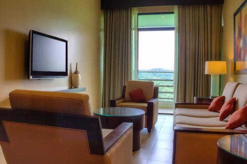 a living room with a couch and a tv at Summit Rainforest Golf Resort & All Inclusive in Paraíso
