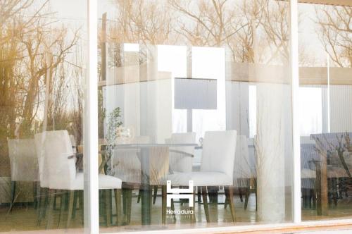 a dining room table with white chairs in a window at Herradura Hotel Suites in Neuquén