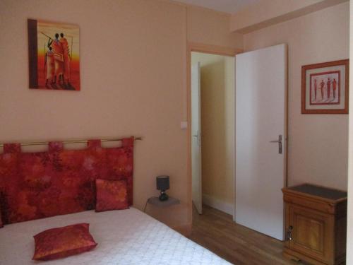 ル・モンドールにある'Mont-Dore-Toir' paisibleのベッドルーム1室(赤いヘッドボード付きのベッド1台付)