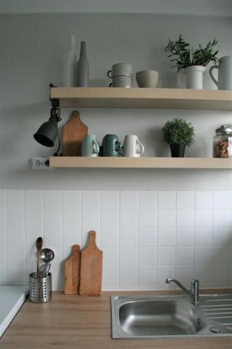 - une cuisine avec évier et étagères avec casseroles et poêles dans l'établissement Profitez De La Vue !, à Banyuls-sur-Mer