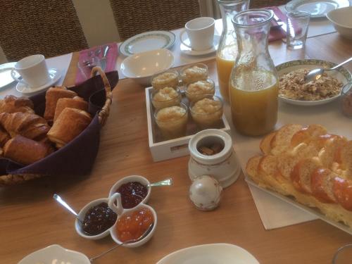 une table avec un petit-déjeuner composé de pain et de jus d'orange dans l'établissement La Maison du Parc, aux Épesses