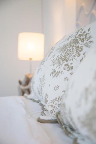 a row of pillows on a bed with a lamp at Elenis Philoxenia in Ixia