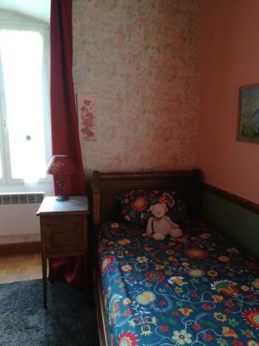 - un ours en peluche assis sur un lit dans une chambre dans l'établissement La Tour de Seythenex, à Seythenex