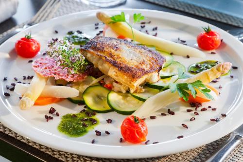 a white plate with food on a table at BRIT HOTEL Confort CAMBRAI in Cambrai