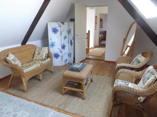 ein Wohnzimmer mit 2 Stühlen und einem Tisch in der Unterkunft Les Chouettes in Callac