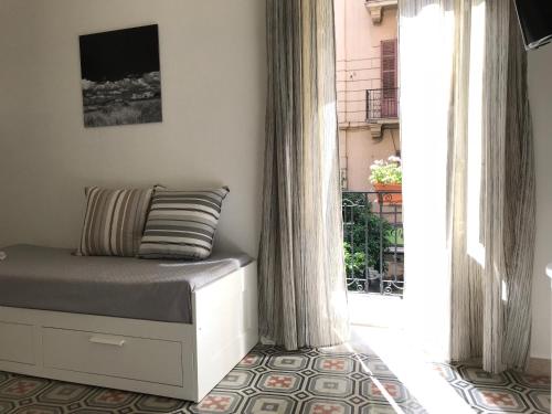 a bedroom with a bed and a large window at Fofino's rooms in Palermo