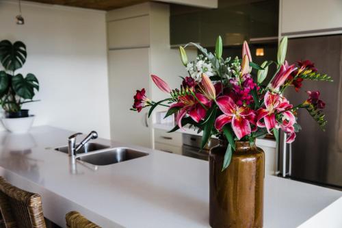 a vase filled with flowers sitting on a kitchen counter at The Narrows Landing Hotel in Hamilton