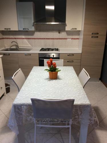 a kitchen with a table with a vase of flowers on it at Affittacamere LA PISANA in Porto SantʼElpidio