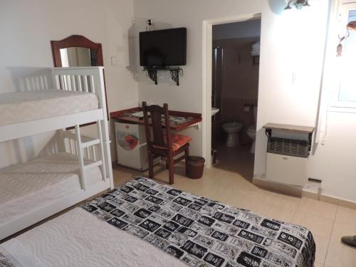 1 dormitorio con 2 literas y TV en Hosteria Las Piedras en Puerto Madryn